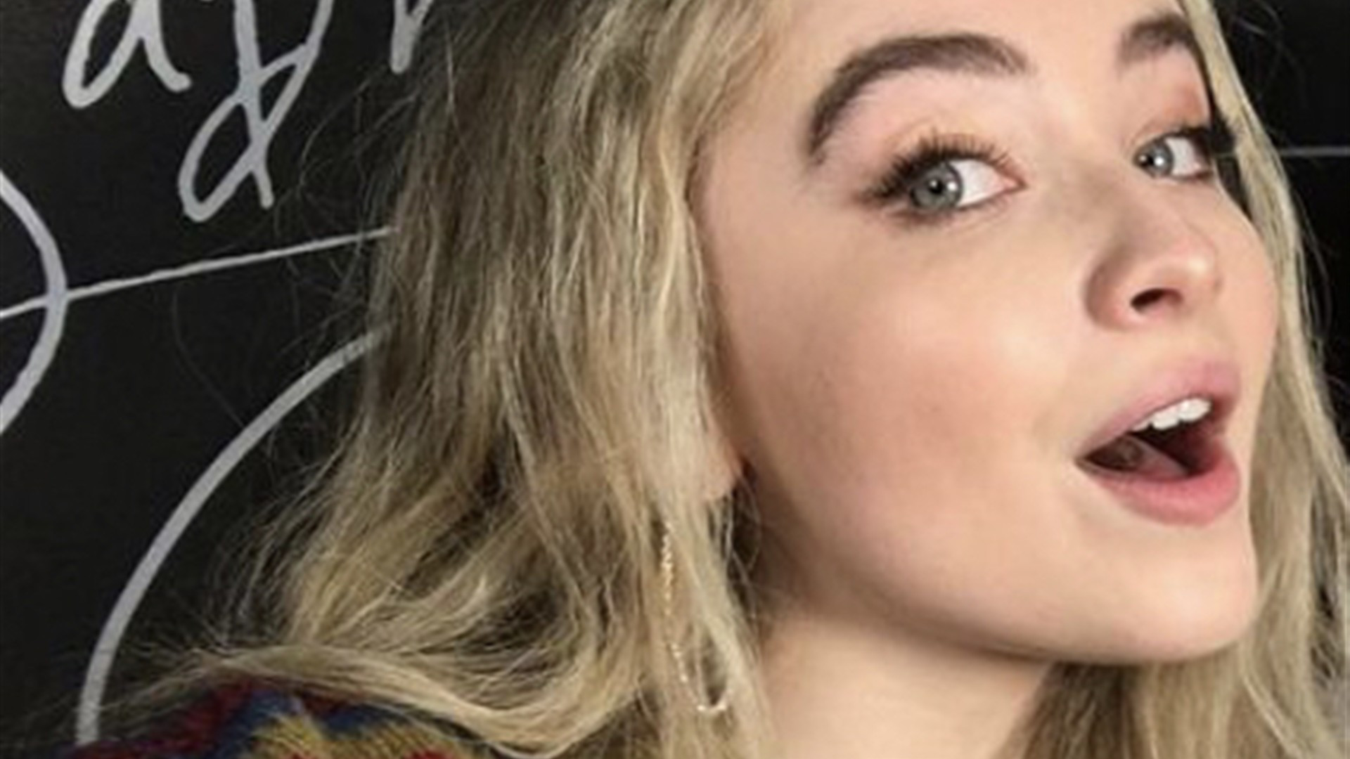Sabrina Carpenter singing live in concert with microphone