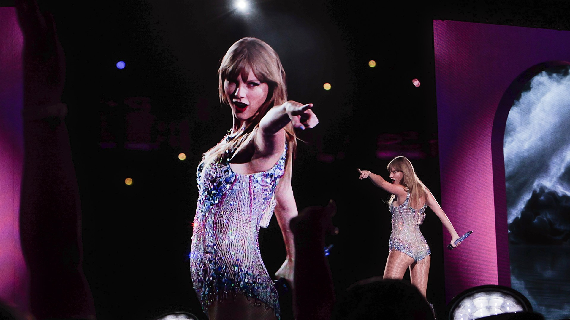 Taylor Swift performing live in shimmering bodysuit on stage