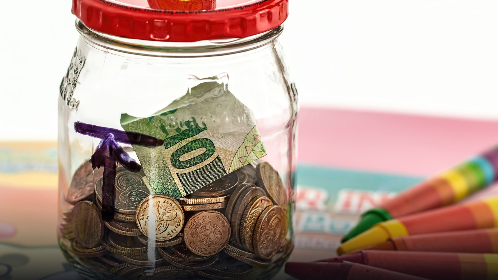 A classic ceramic piggy bank with savings coins on a clean surface.