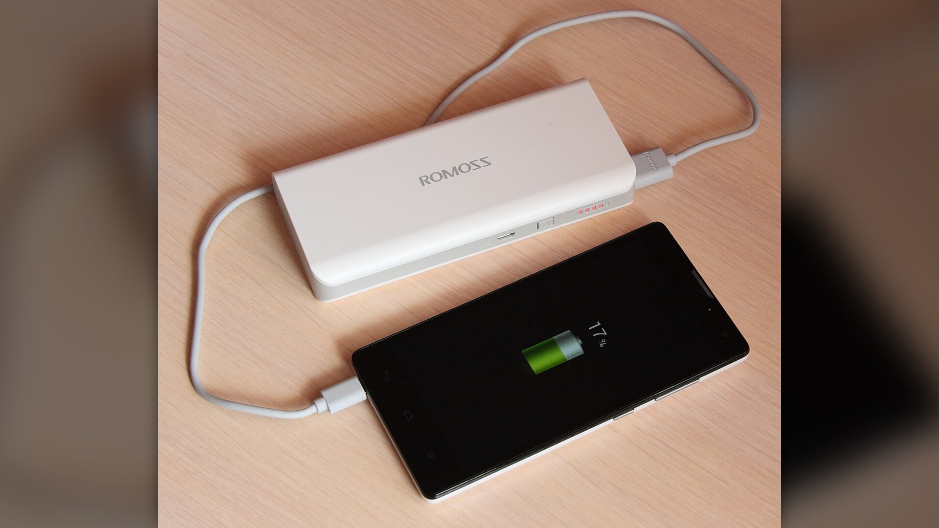 A high-capacity external power bank charging a smartphone.
