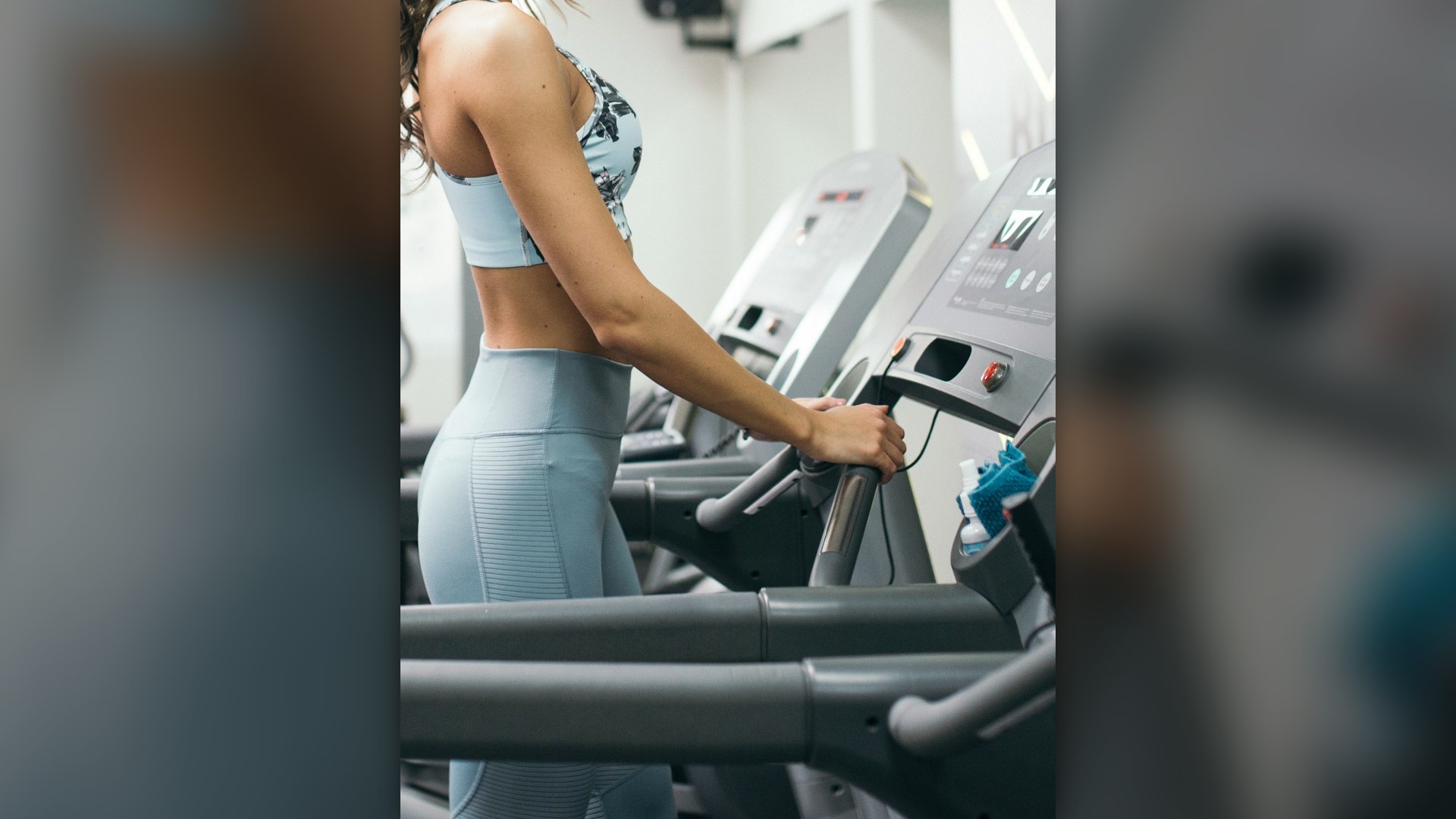 Woman running with high intensity on a treadmill in a fitness gym.