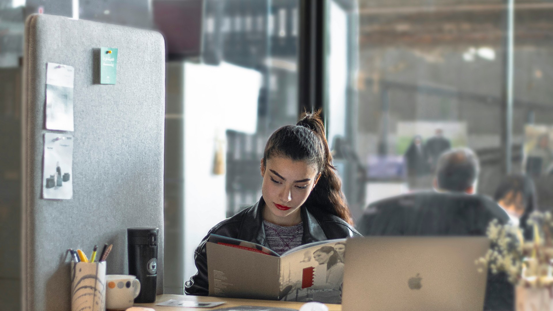 Corporate employee working on a laptop at an office table.