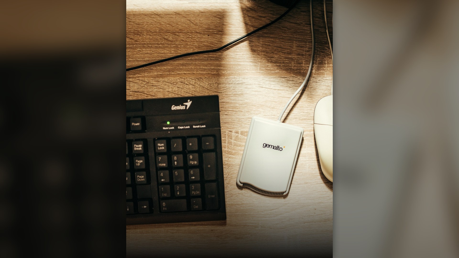 Desktop computer mouse and keyboard positioned on a wooden office desk.