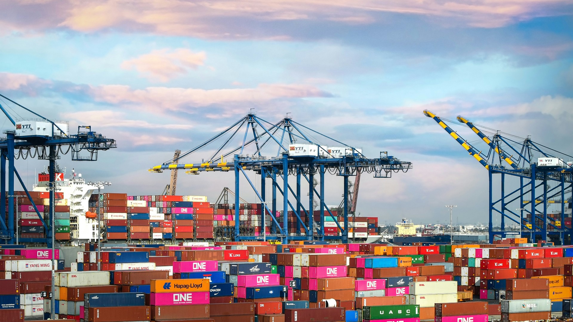 Cargo vessel transporting heavy shipping container cranes into port