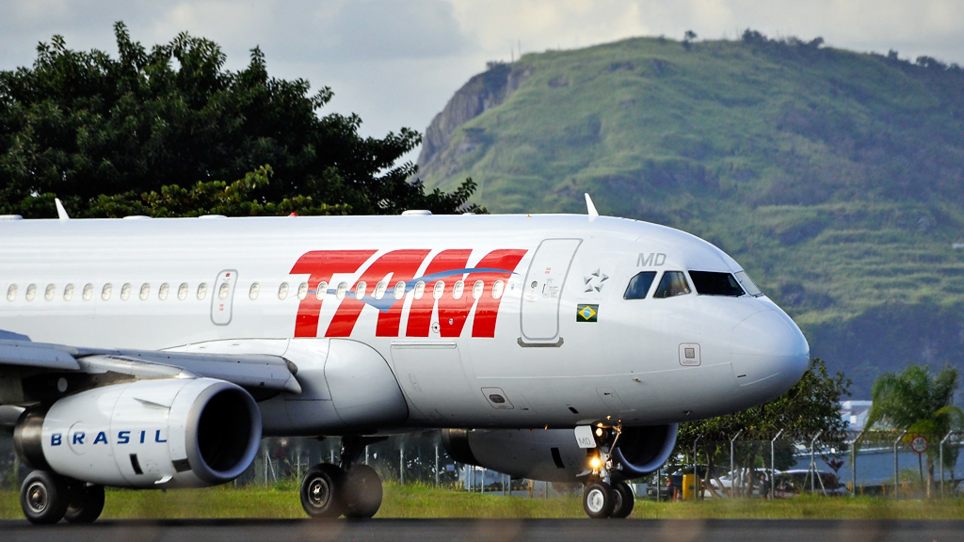 TAM airliner touching down on the bayfront runway at Santos Dumont Airport in Rio de Janeiro.