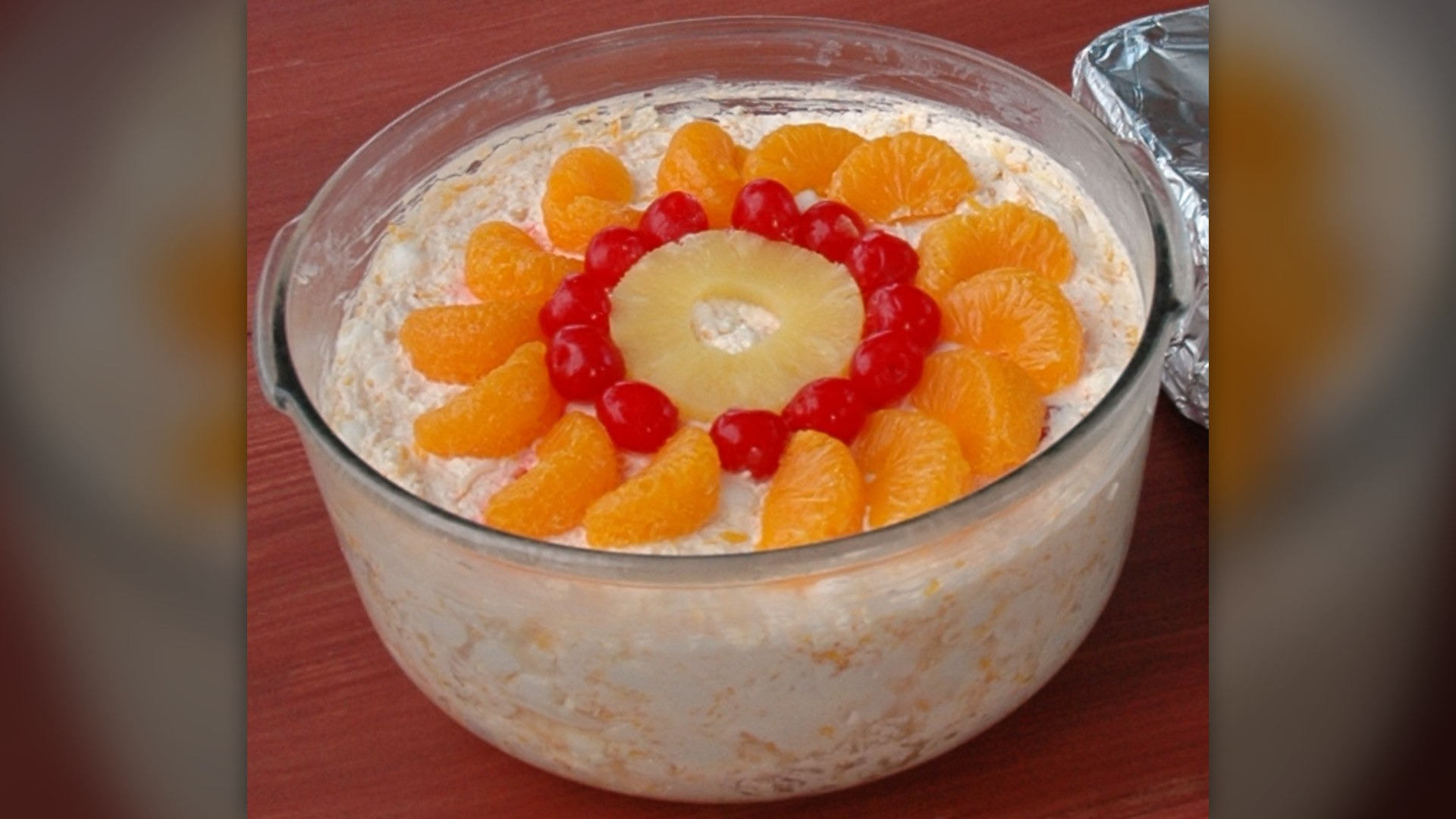 A serving of American Ambrosia salad made with mini marshmallows, whipped cream, coconut, and fruit.