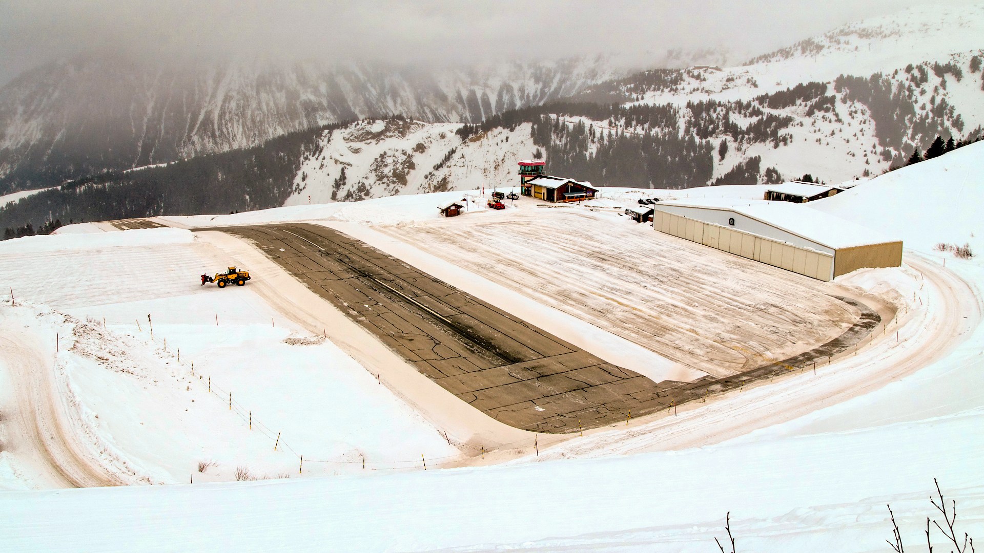 Snow-covered steeply sloped alpine runway at Courchevel Altiport in the French Alps.