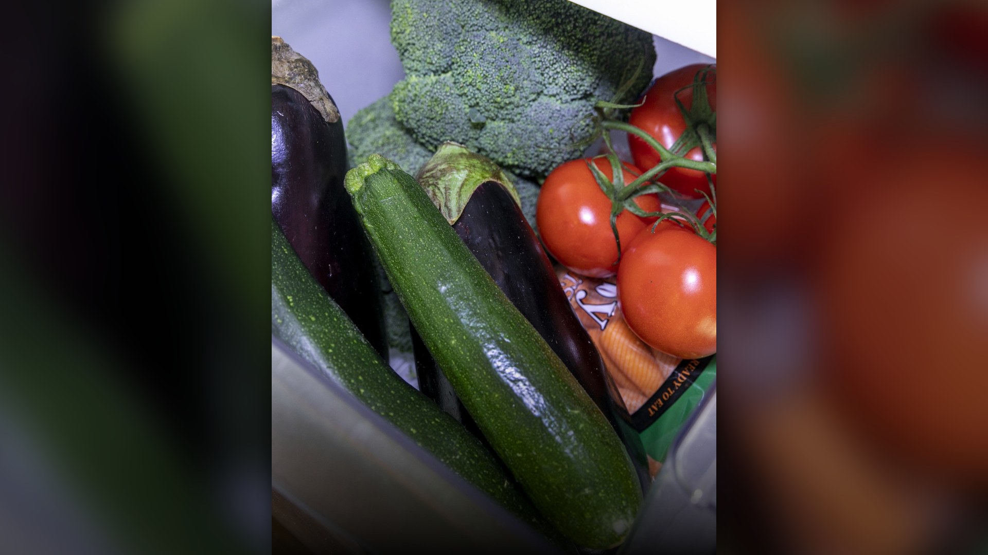 Fresh vegetables stored inside a household refrigerator crisper drawer.