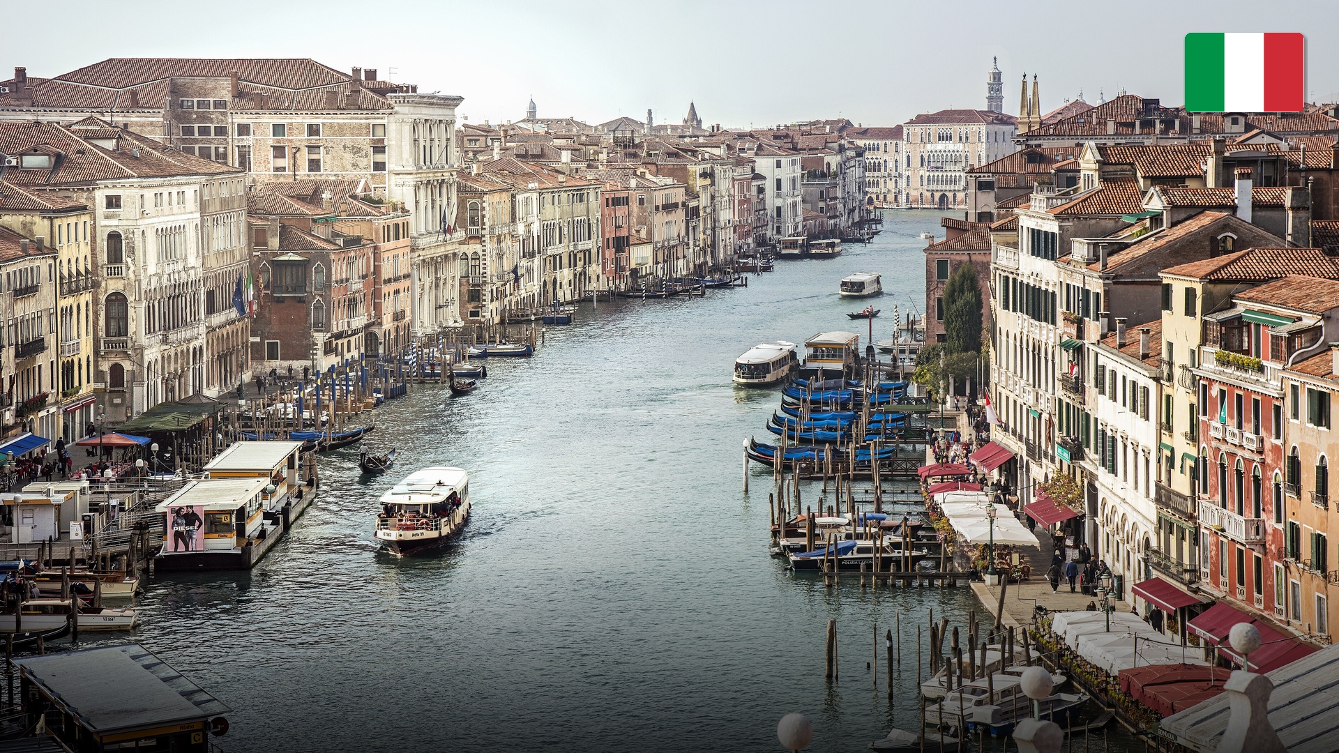 Gondolas navigating the Grand Canal in Venice in front of historic palaces.
