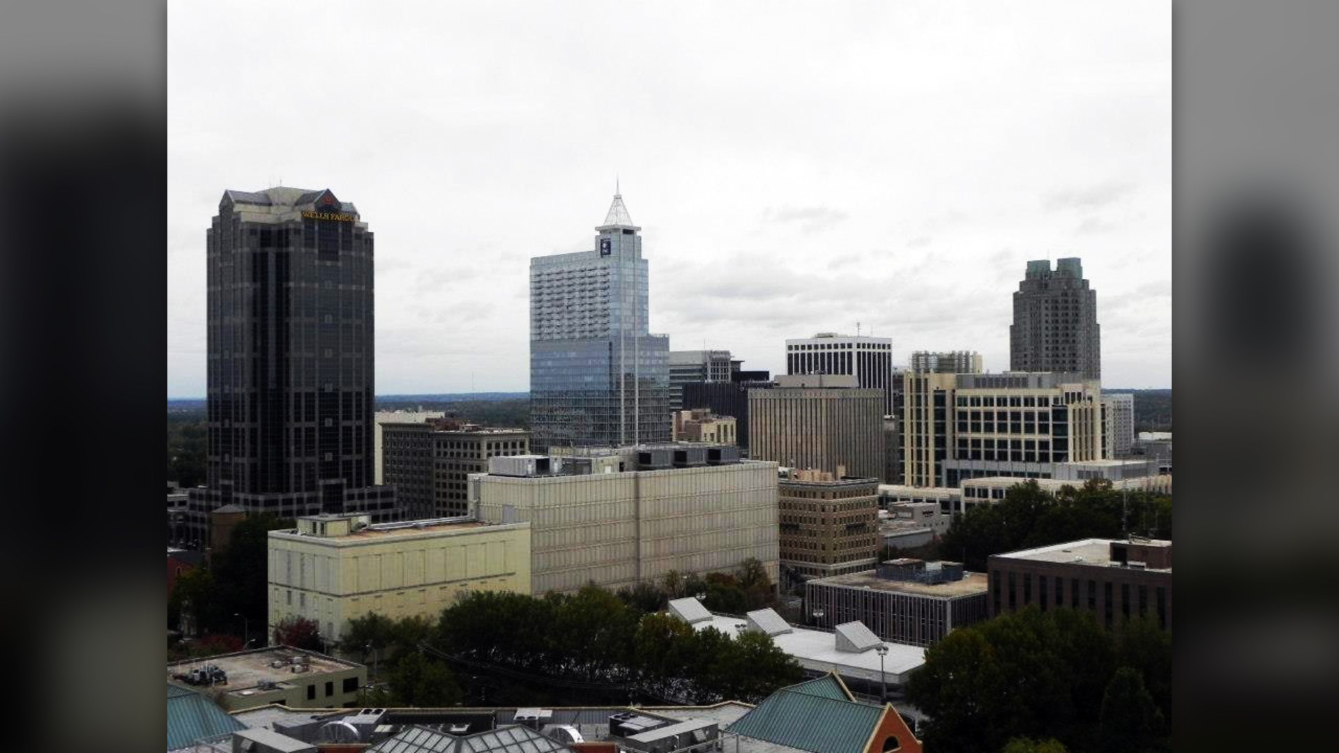 Downtown skyline of Raleigh, North Carolina surrounded by oak trees.