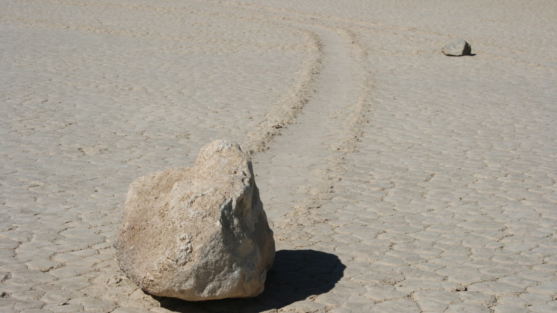 Sailing boulder leaving a long furrow trail across Death Valley's Racetrack Playa mudflat.