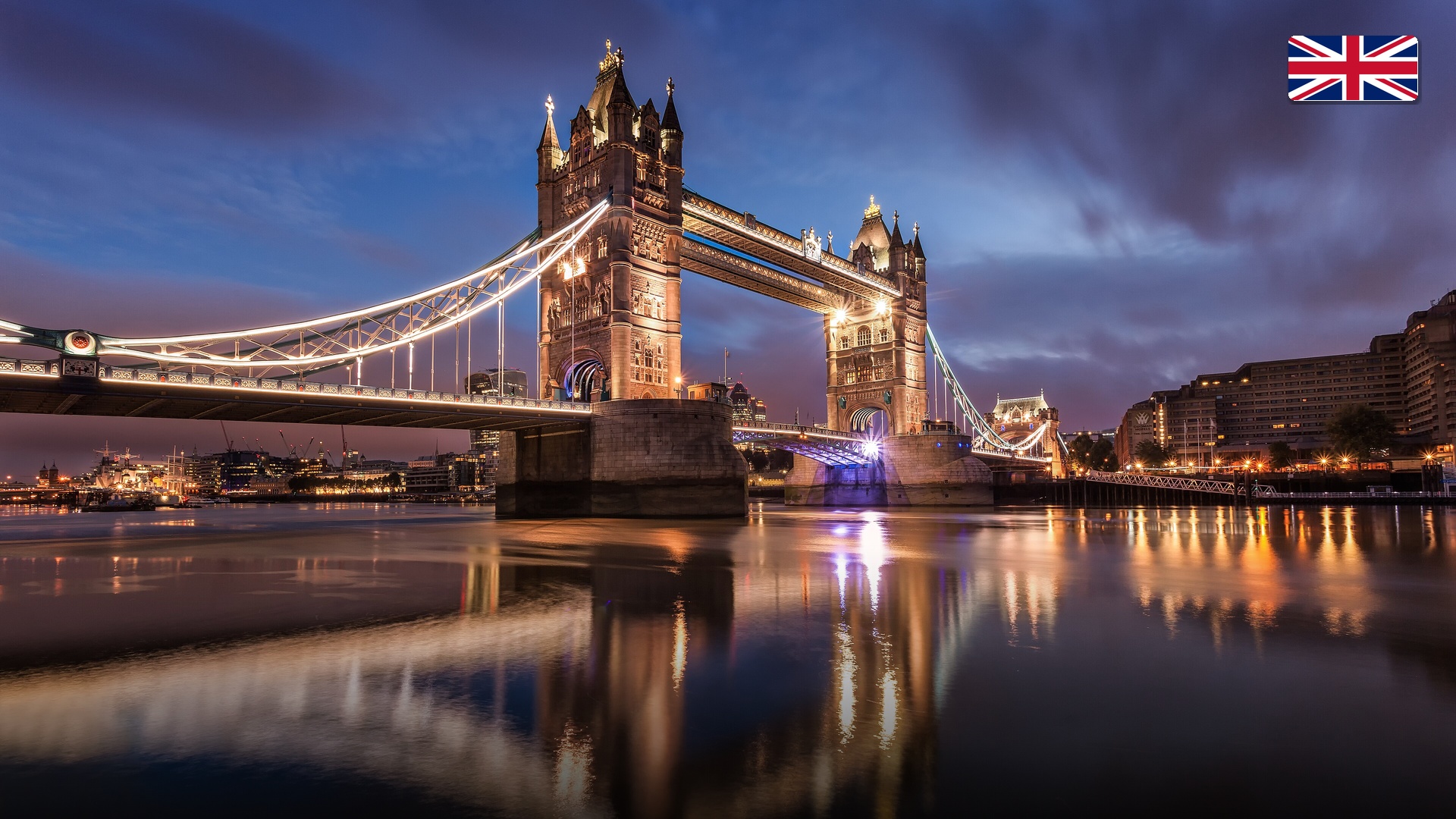 London Tower Bridge illuminated at dusk spanning the River Thames.