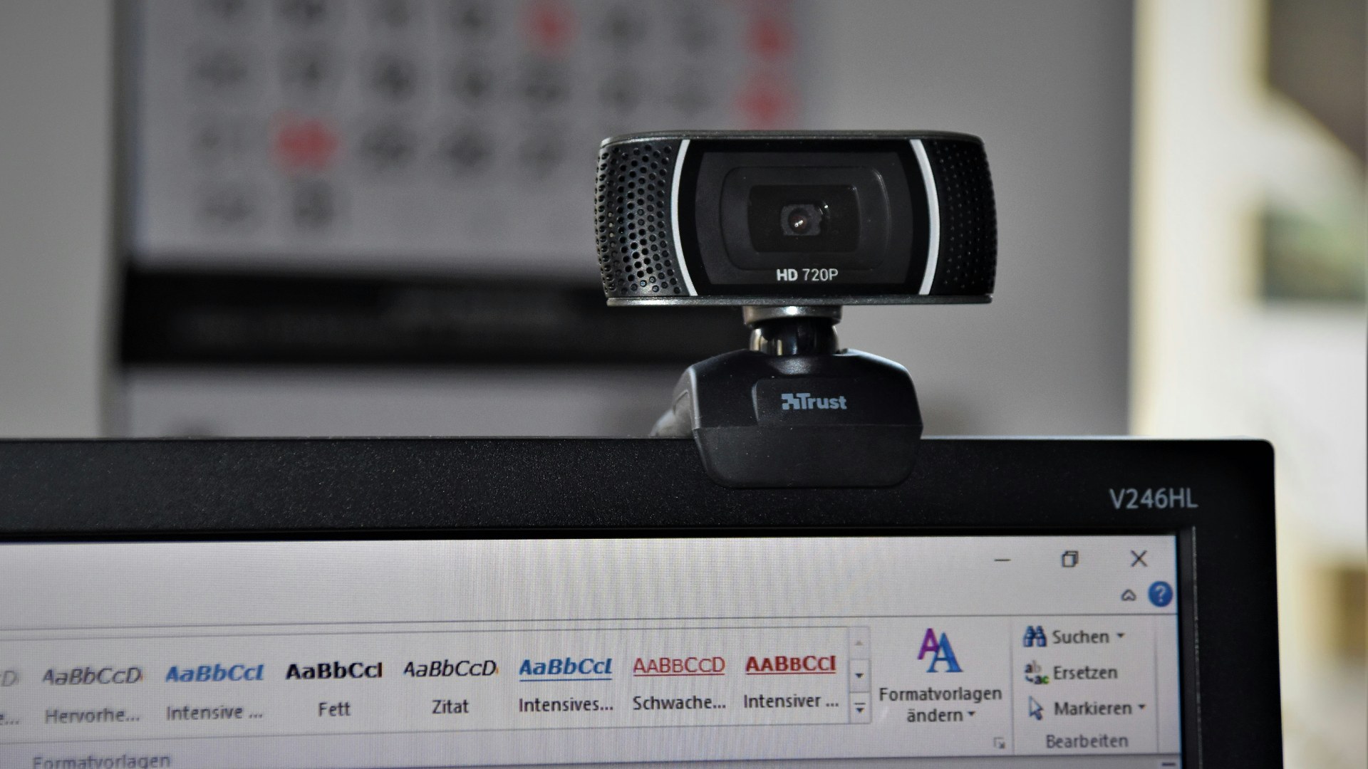Close-up of a desktop webcam mounted on a computer monitor in a home office.