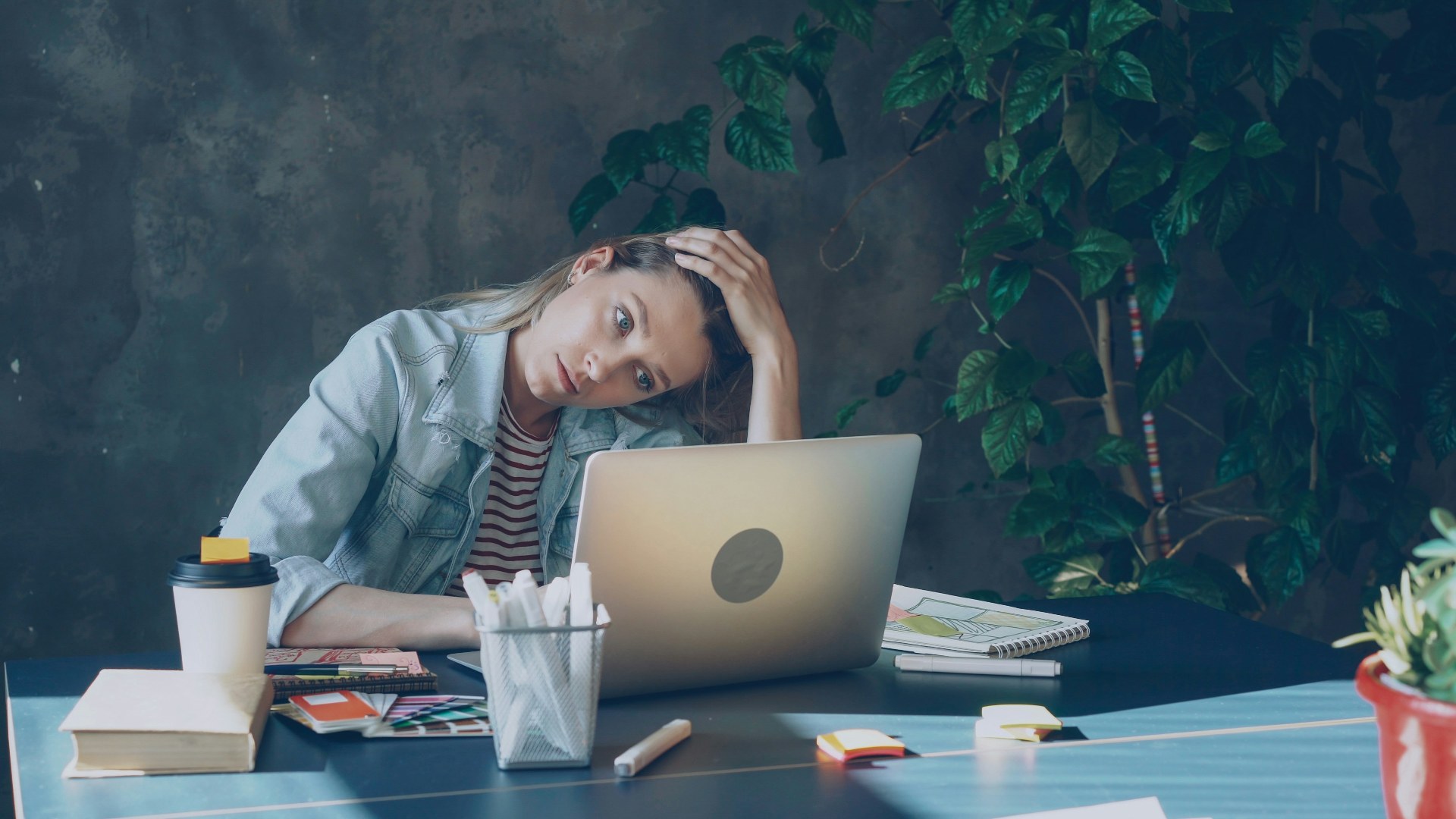 Stressed corporate employee looking at her laptop screen during a video meeting.