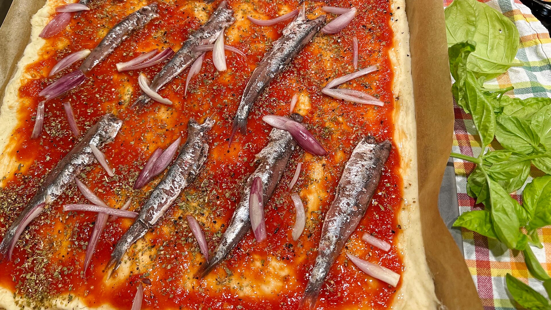 Freshly baked anchovy pizza on baking paper