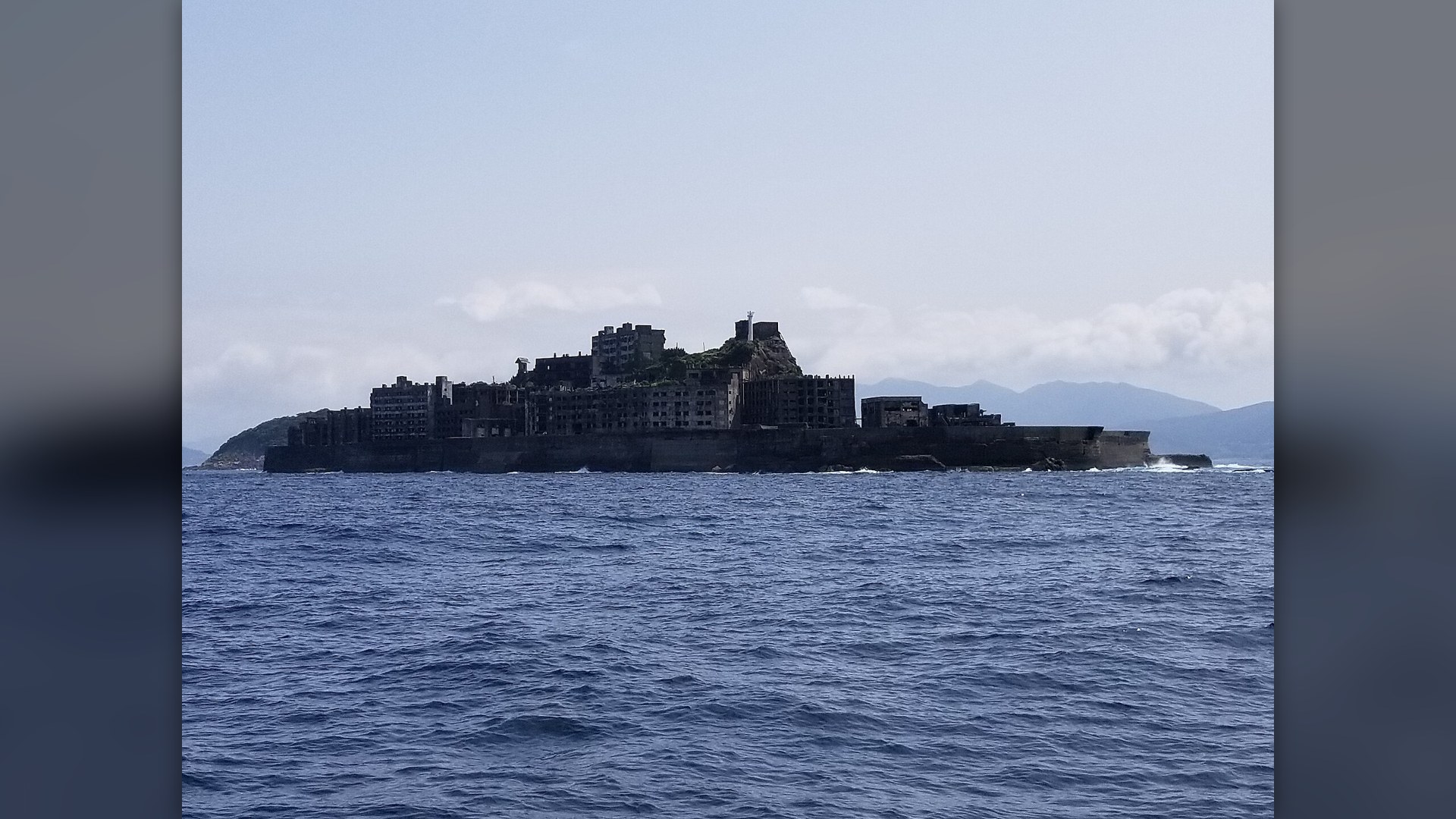 Decaying concrete apartment blocks rising from the sea on Hashima Island