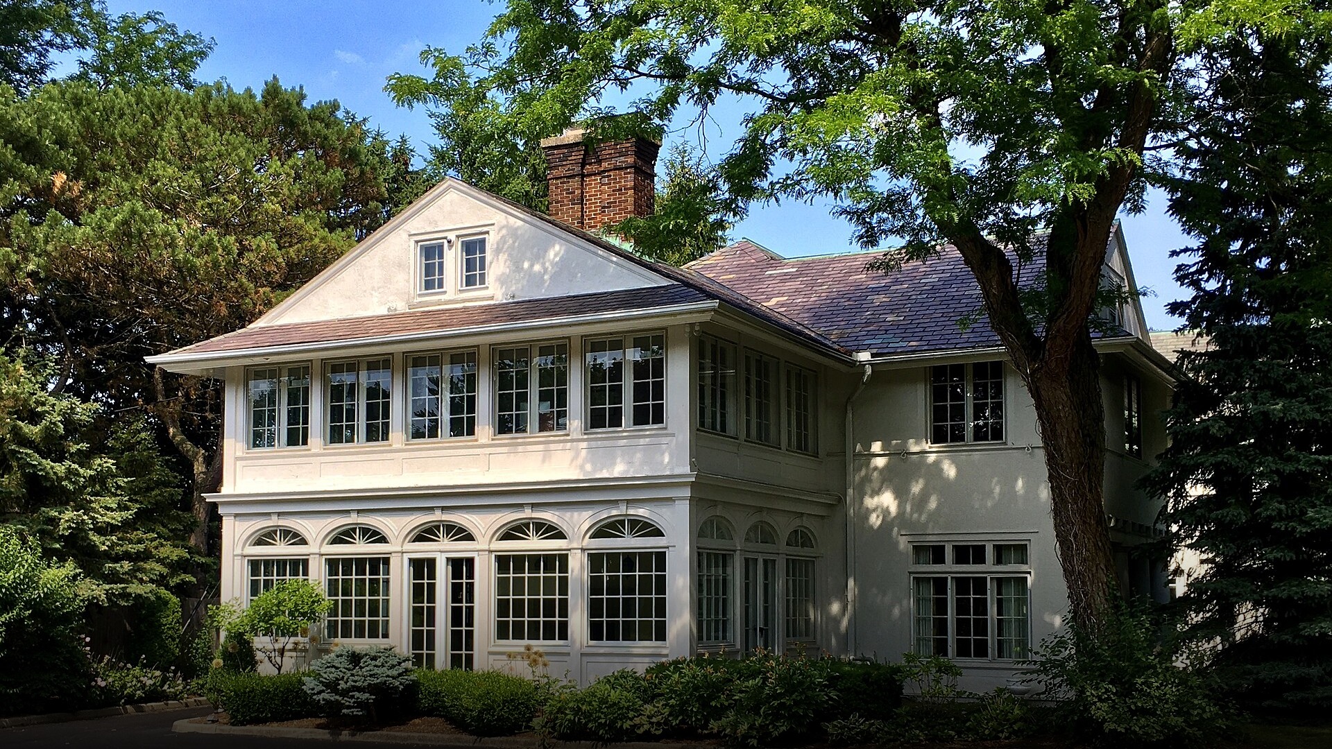 Two-story American suburban single-family house with a manicured green lawn.