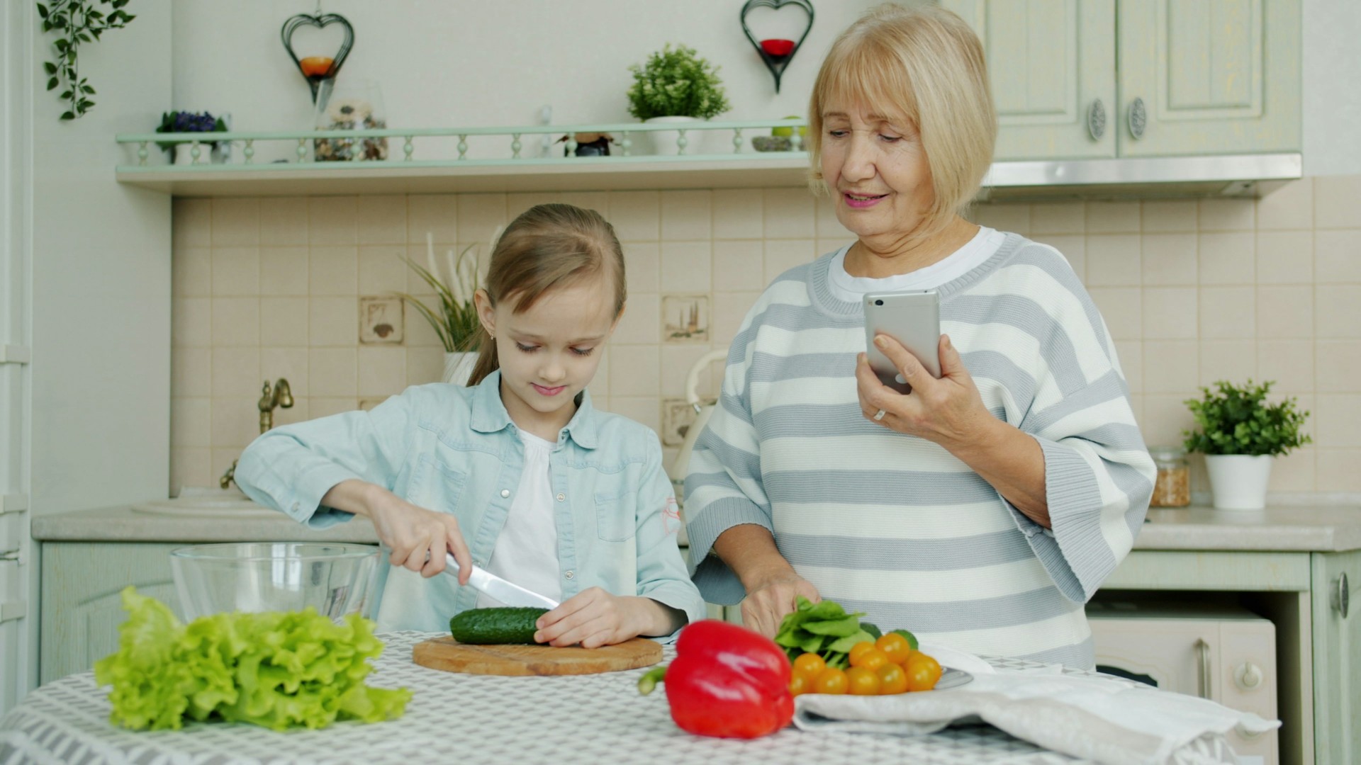 Loving grandmother and granddaughter baking together in the kitchen with flour on their hands.