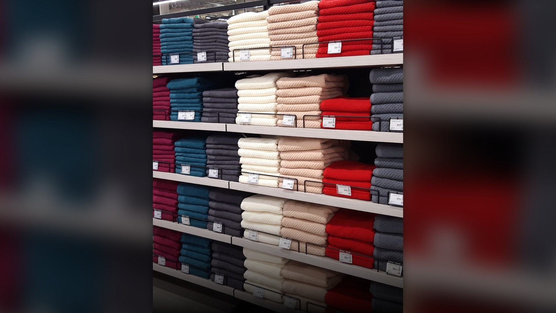 Folded cotton bath towels stacked on shelves.