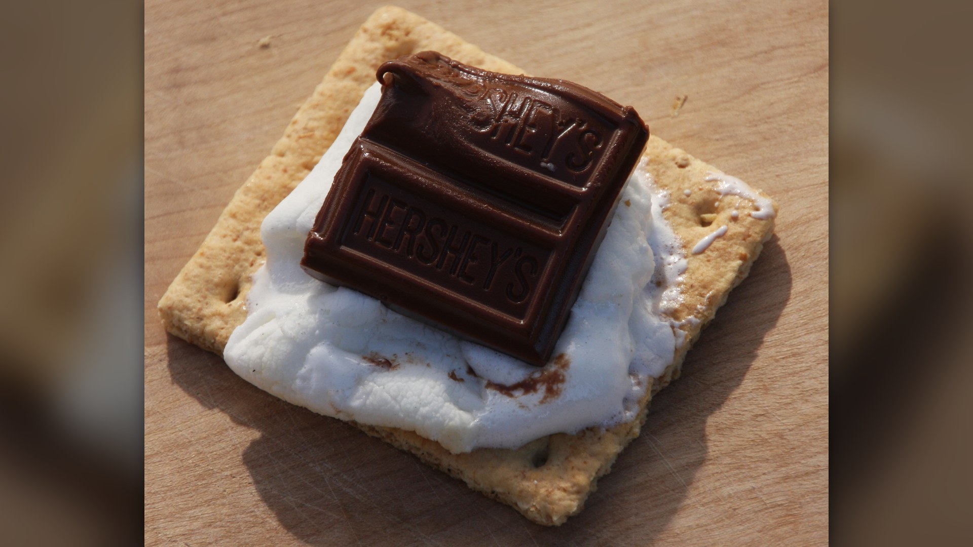 An open-faced campfire s'more made with graham cracker, toasted marshmallow, and Hershey's chocolate.