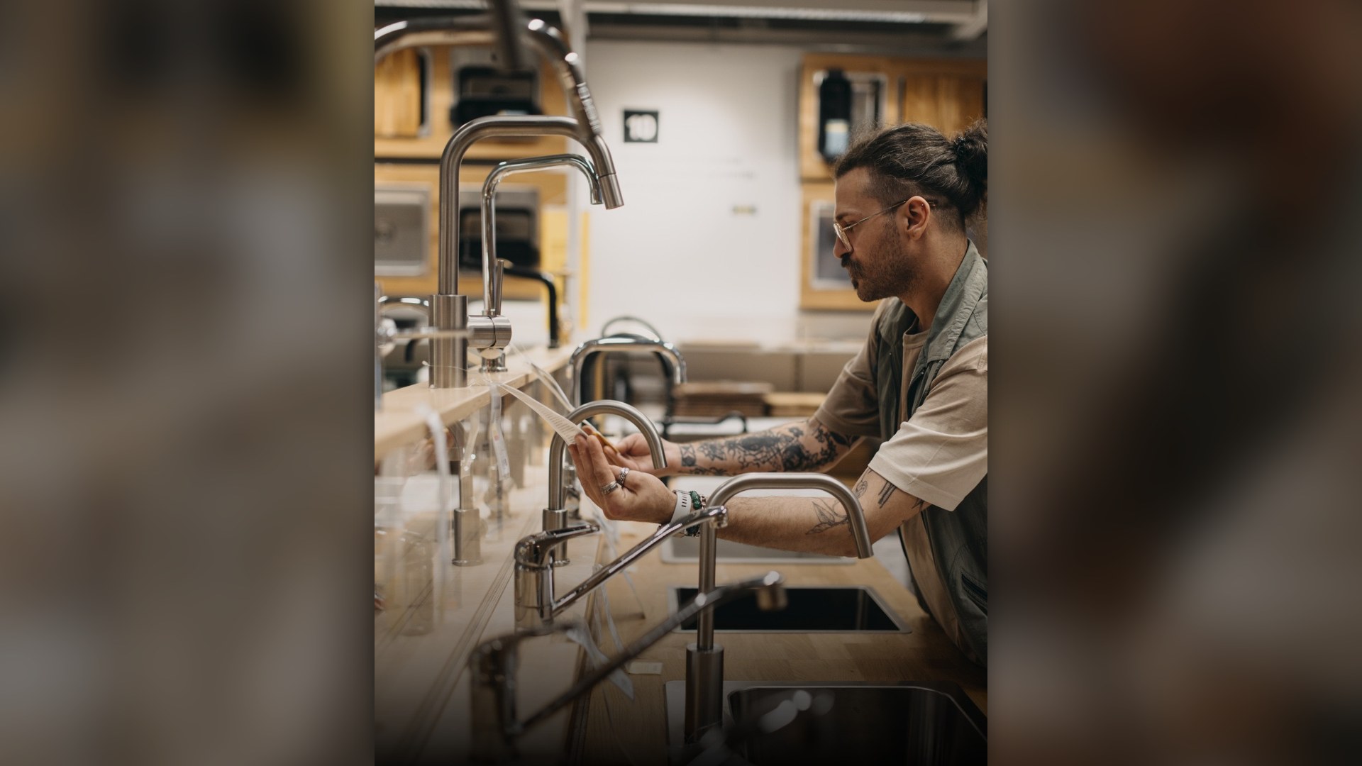 Hand touching a modern stainless steel kitchen sink faucet handle.