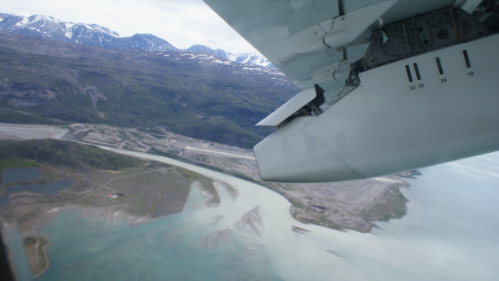 Aerial view of the fjord runway surrounded by mountains and icebergs at Narsarsuaq Airport, Greenland.