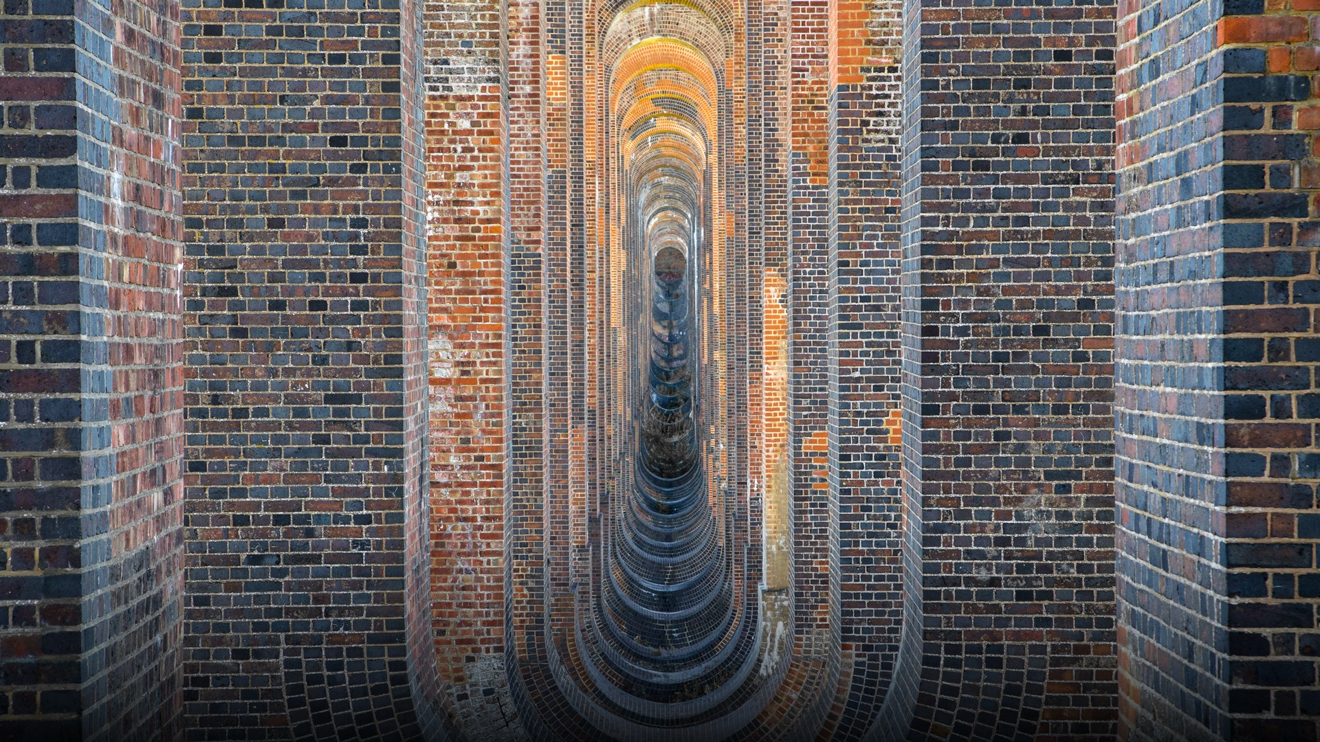 The elegant brick arches and classical balustrades of the Victorian Ouse Valley Viaduct in Sussex.