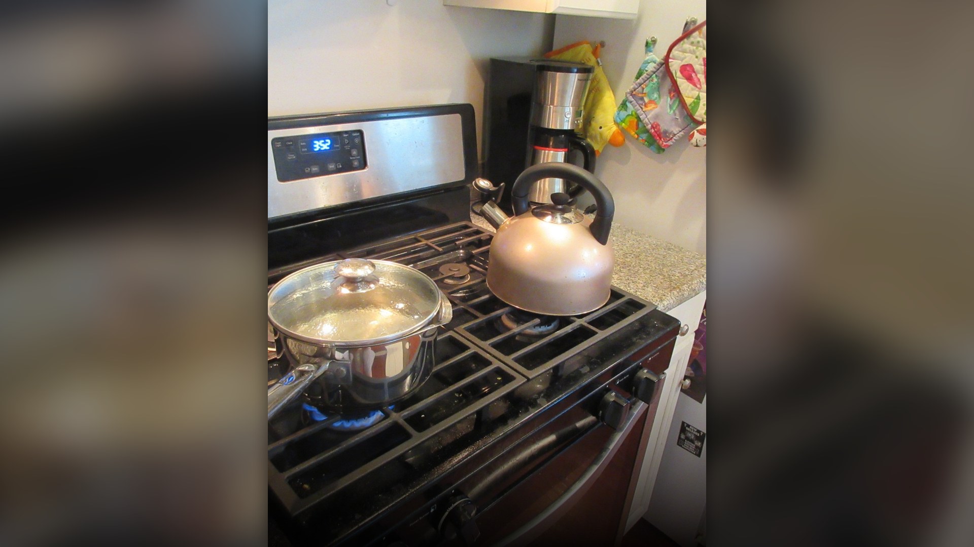 Household kitchen stove range showing burner grates and front control knobs.