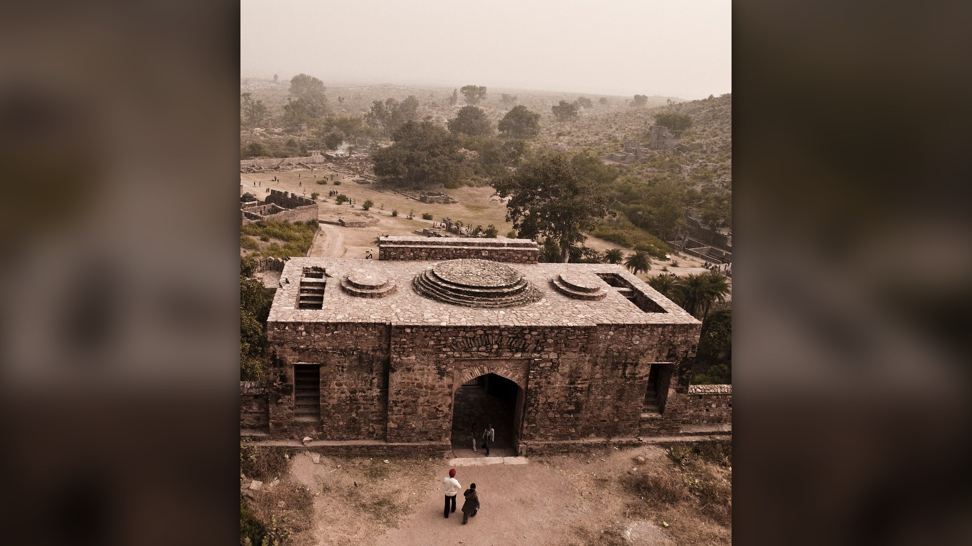 Crumbling stone palaces and temples of Bhangarh Fort in Rajasthan at dusk