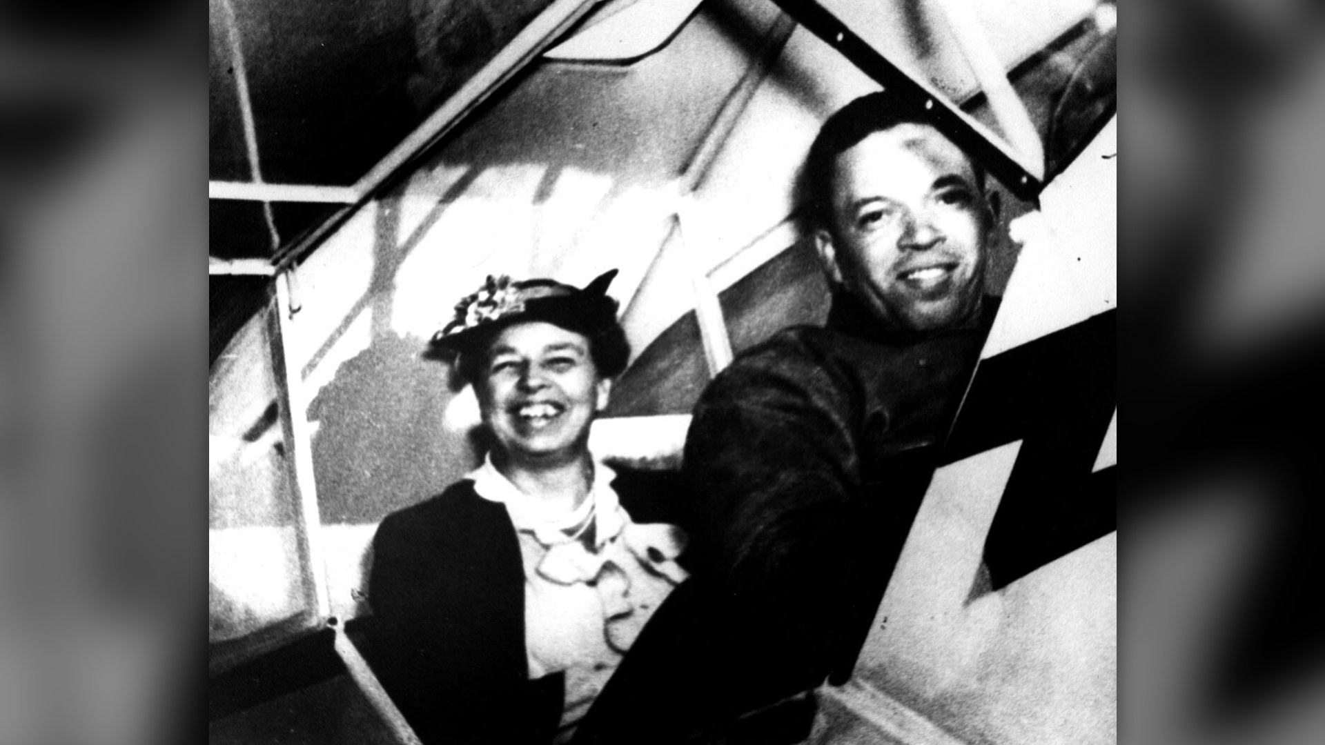 Eleanor Roosevelt smiling beside pilot C. Alfred Anderson in an airplane cockpit.