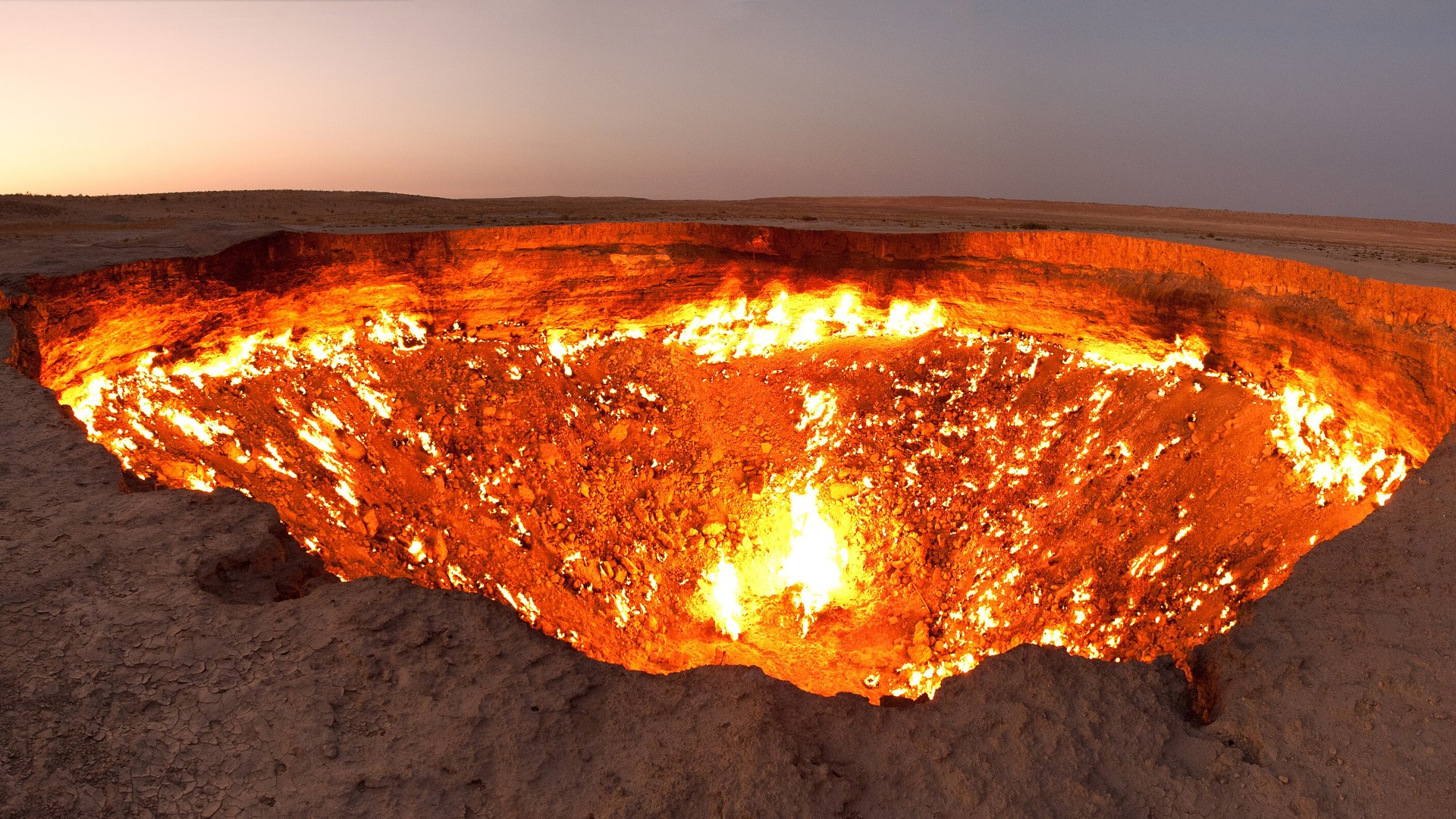 Flames glowing inside the collapsed Darvaza natural gas crater in the Karakum Desert of Turkmenistan.