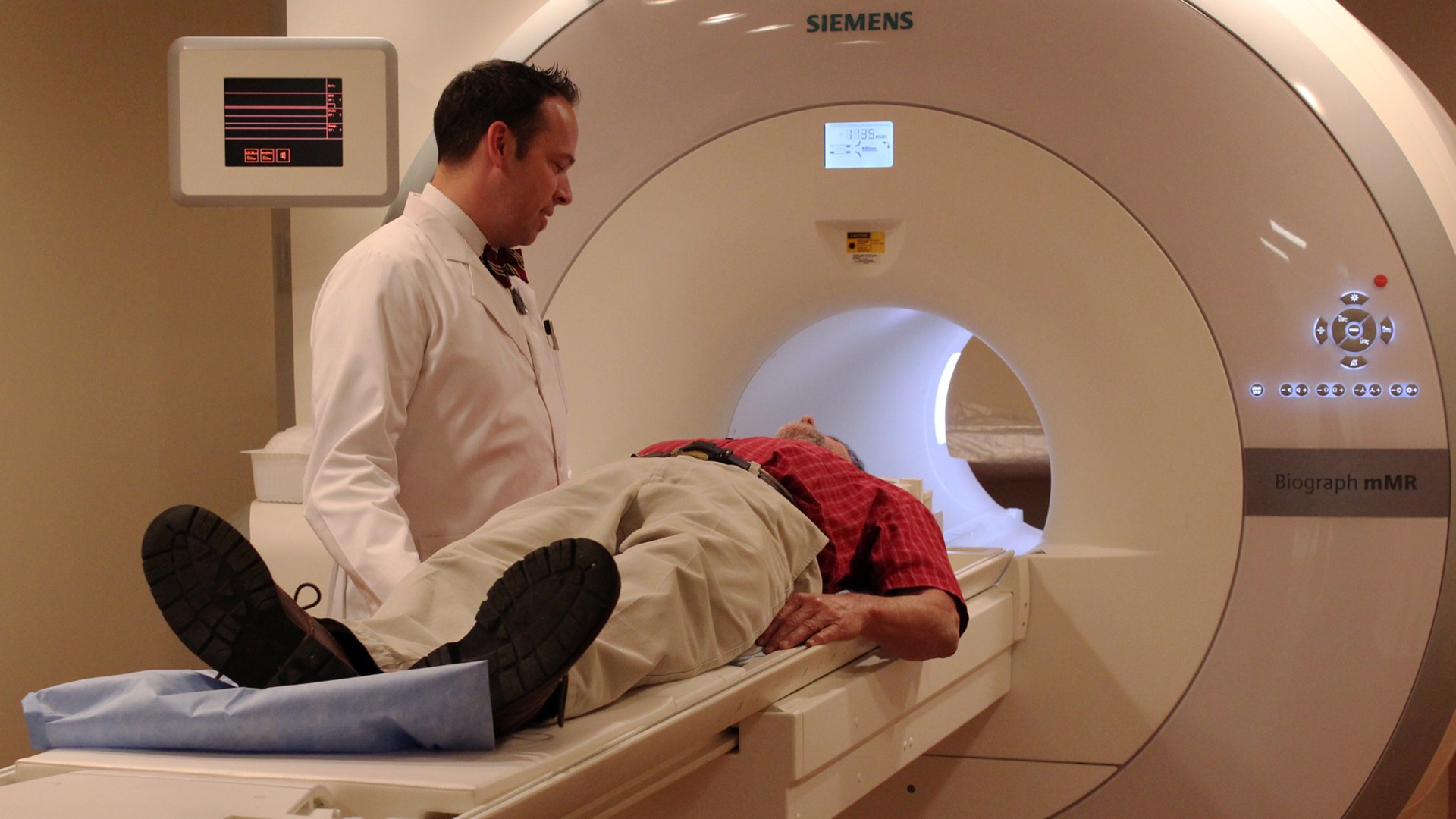 Clinical researcher operating a simultaneous whole-body PET-MRI human brain and neuroimaging scanner.
