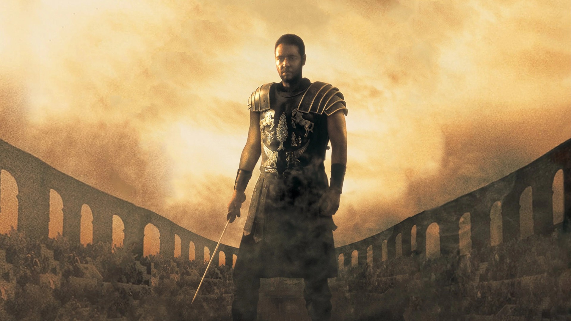 Maximus raises his sword in defiance inside the sandy floor of the Roman Colosseum in Gladiator.