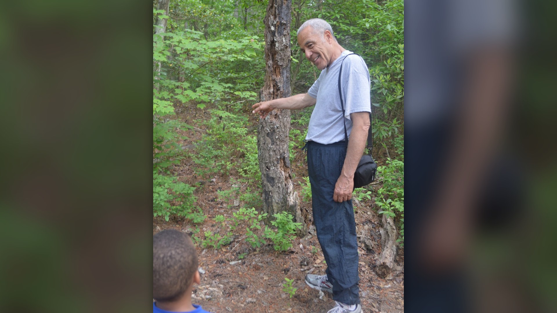 A grandfather showing nature to his grandson outdoors at First Landing State Park in Virginia, USA.