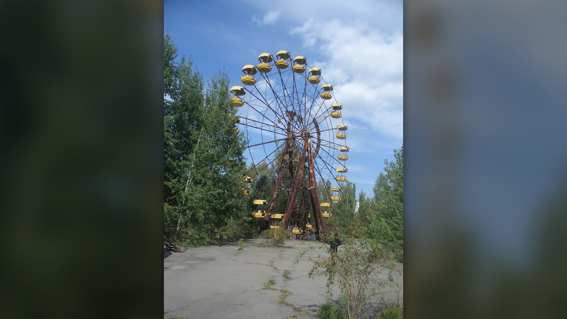 Iconic rusted yellow Ferris wheel standing silent in the abandoned amusement park of Pripyat