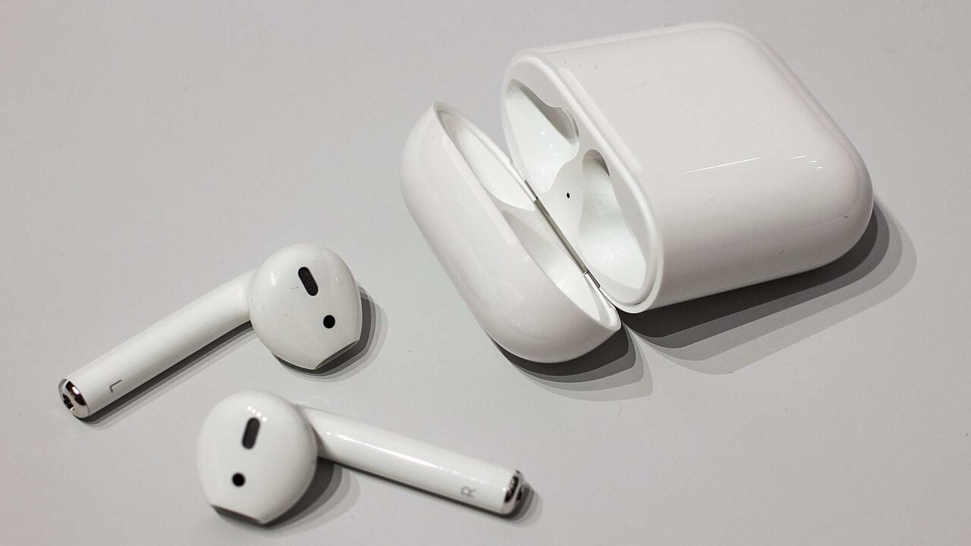 Apple AirPods true wireless earbuds inside white charging case.