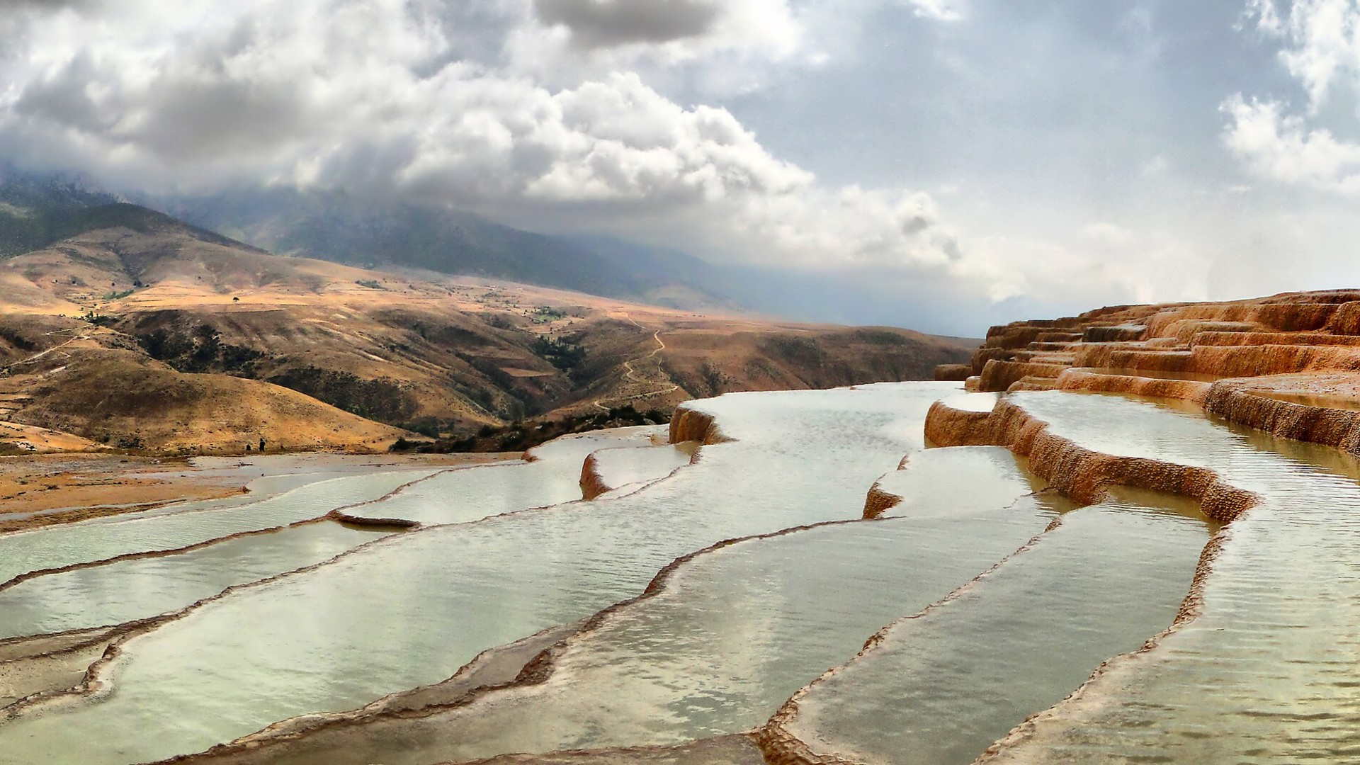 Stepped orange and red iron-oxide travertine pools at Badab-e Surt in northern Iran.