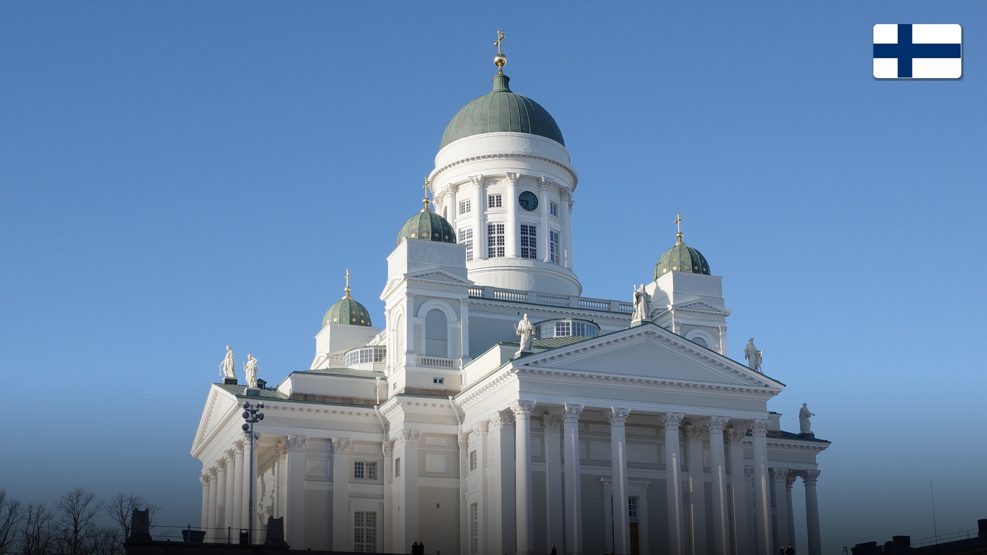 Neoclassical white facade and green domes of Helsinki Cathedral standing over Senate Square.