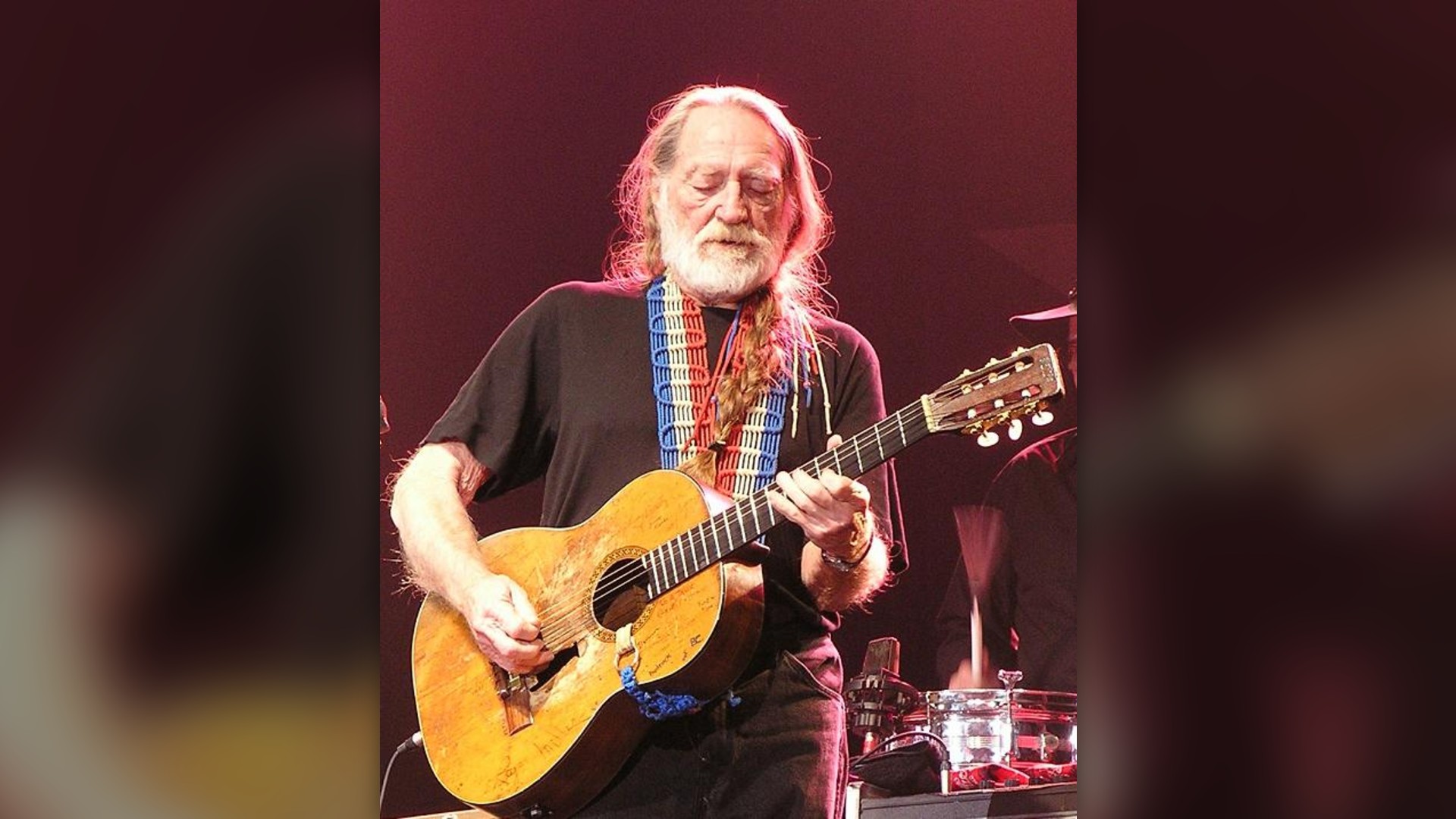 Willie Nelson performing on stage