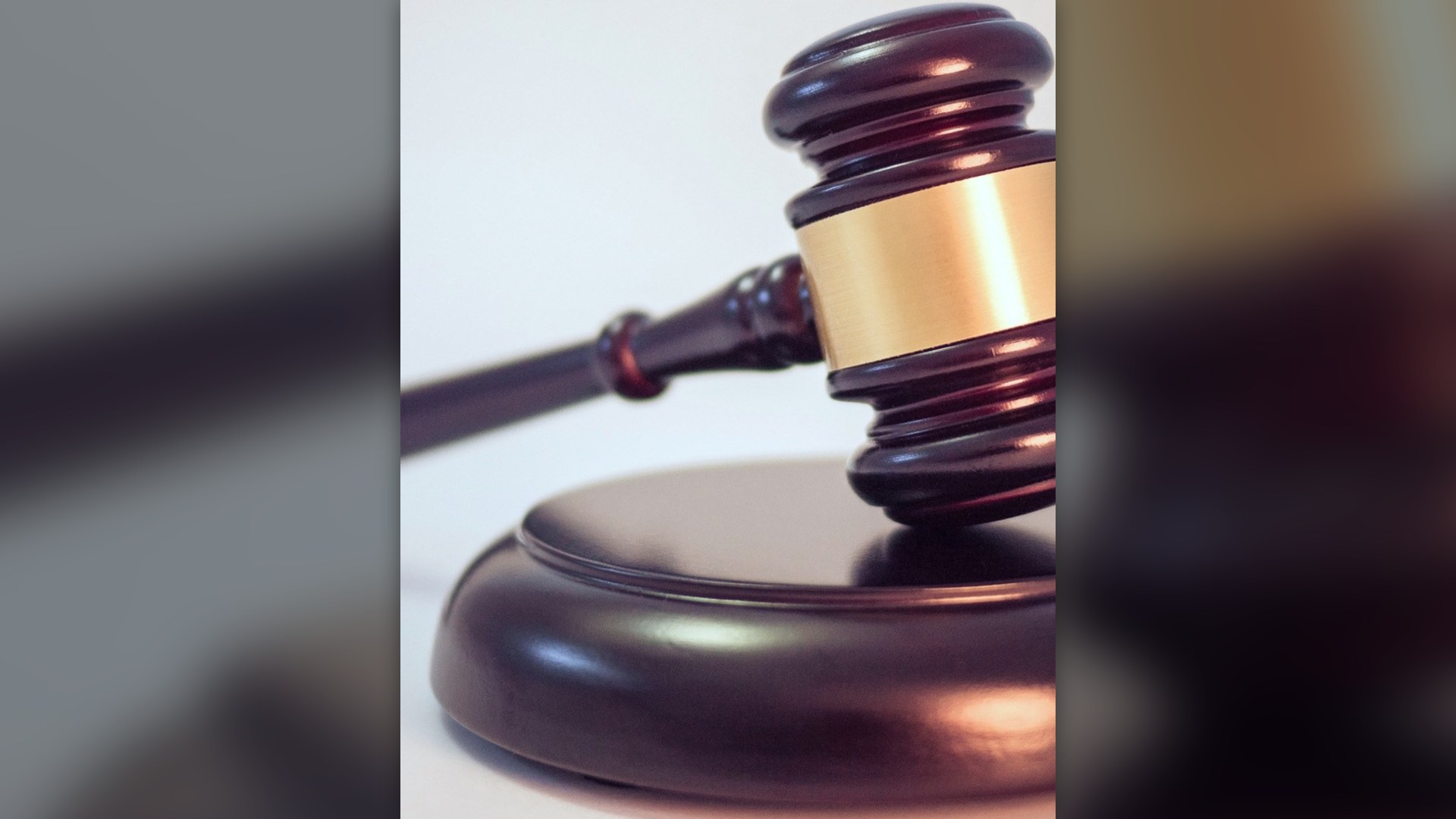 Wooden judicial gavel resting on sound block representing court sentencing