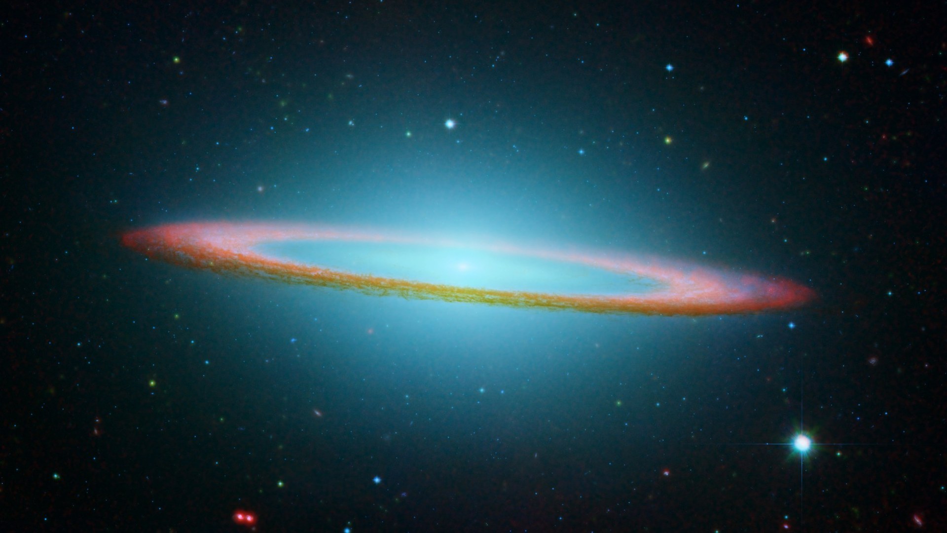 Combined Hubble Space Telescope and Spitzer infrared portrait of the glowing Sombrero Galaxy M104.