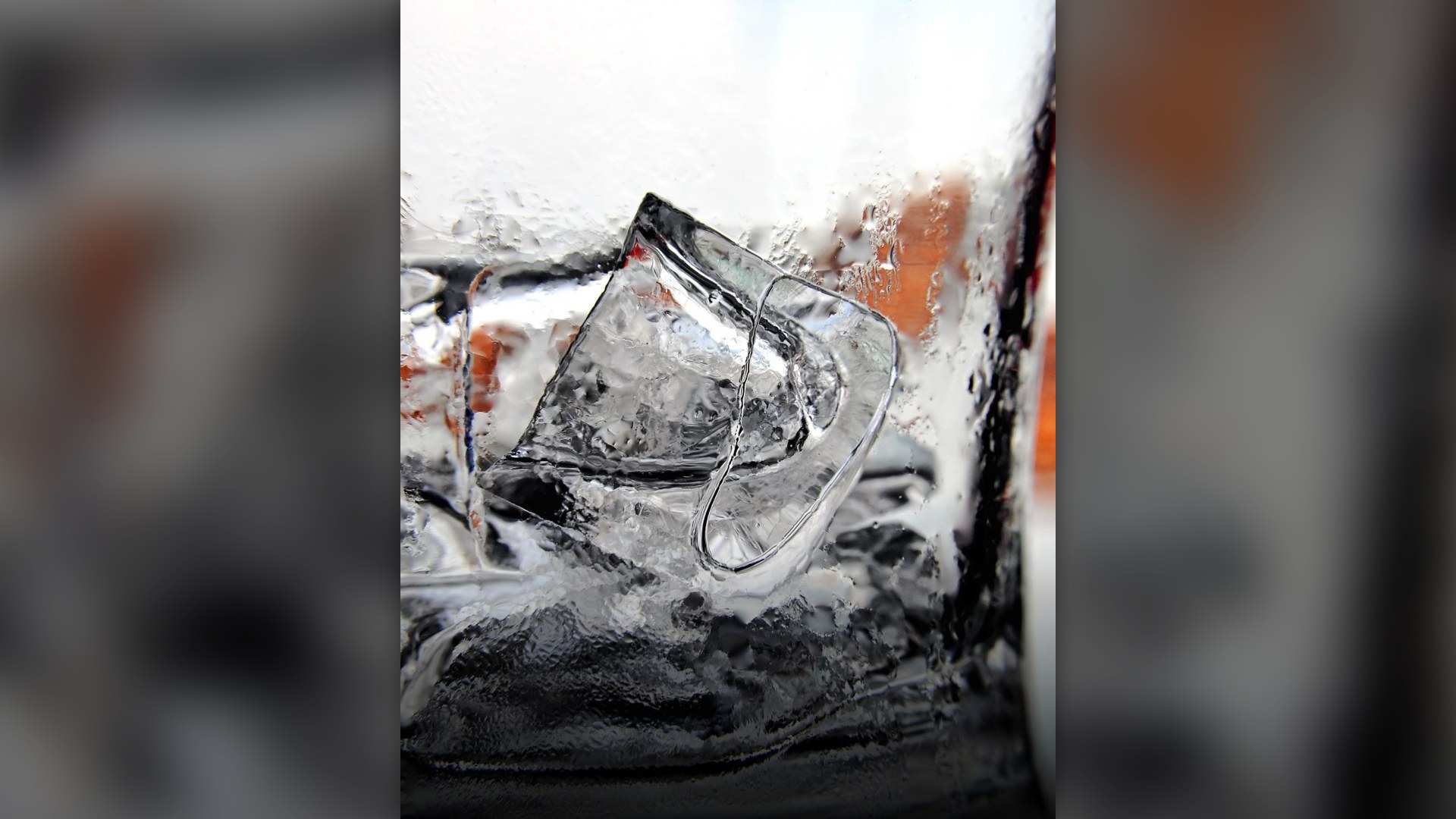 Close-up of clear ice cubes inside a drinking glass.