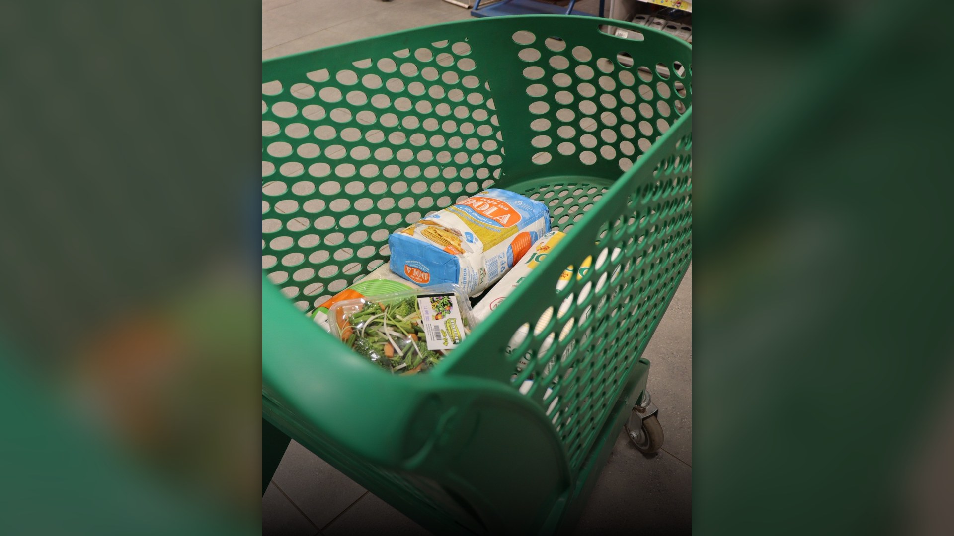 Supermarket shopping cart in a grocery store aisle.