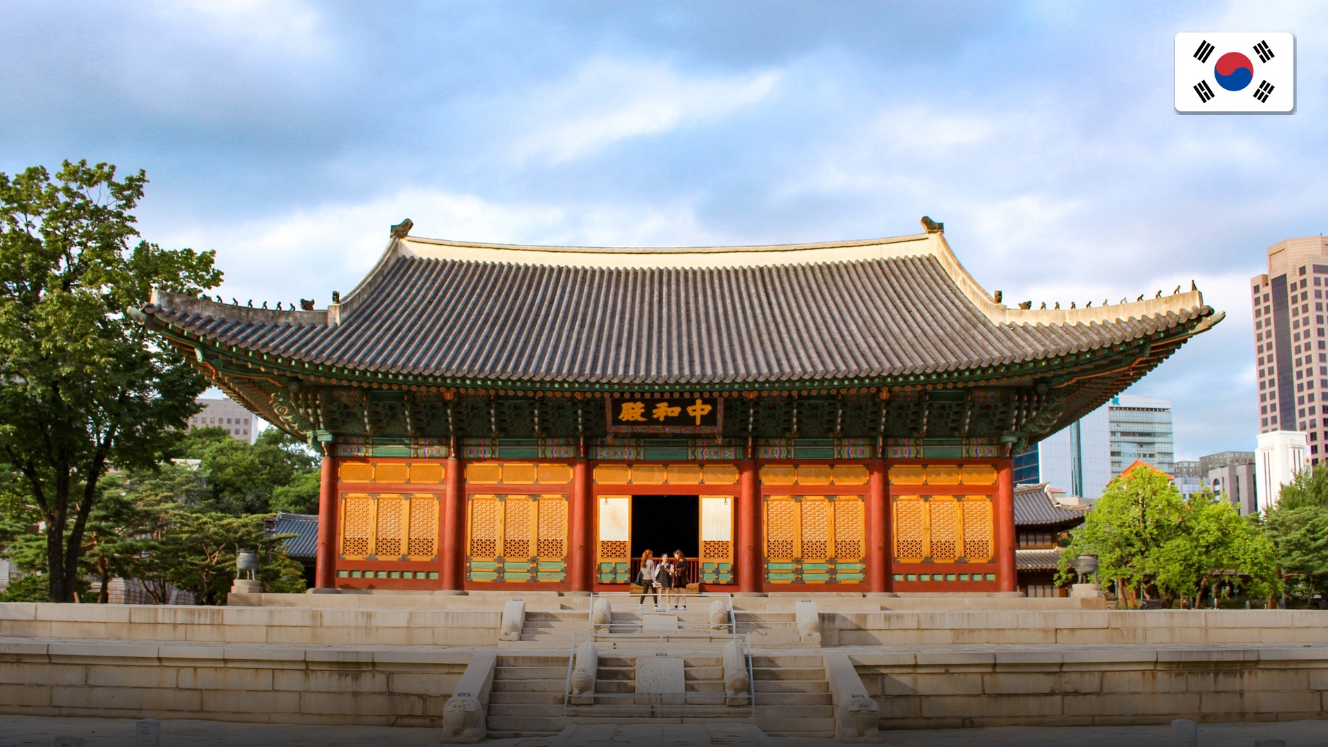 Historic Gyeongbokgung palace juxtaposed against modern downtown Seoul skyscrapers.