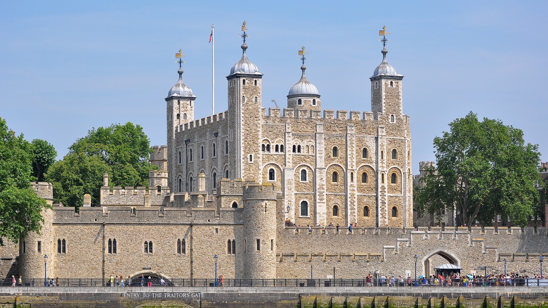 Imposing stone fortress and battlements of the Tower of London viewed across the River Thames