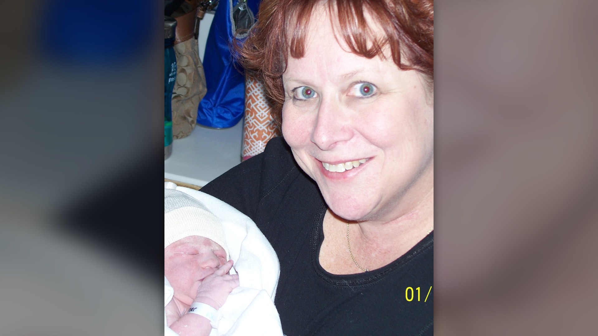 A grandmother cradling and smiling down at her young granddaughter at home.