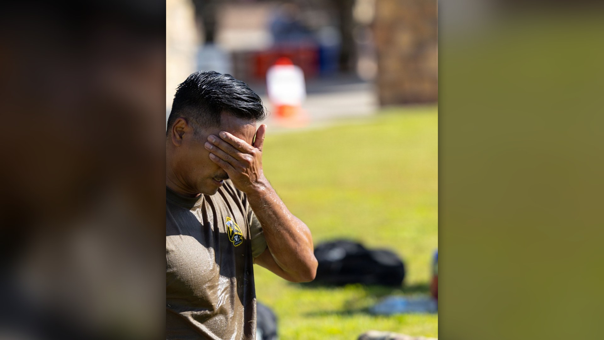 Soldier wiping sweat from forehead following an intense physical training event.