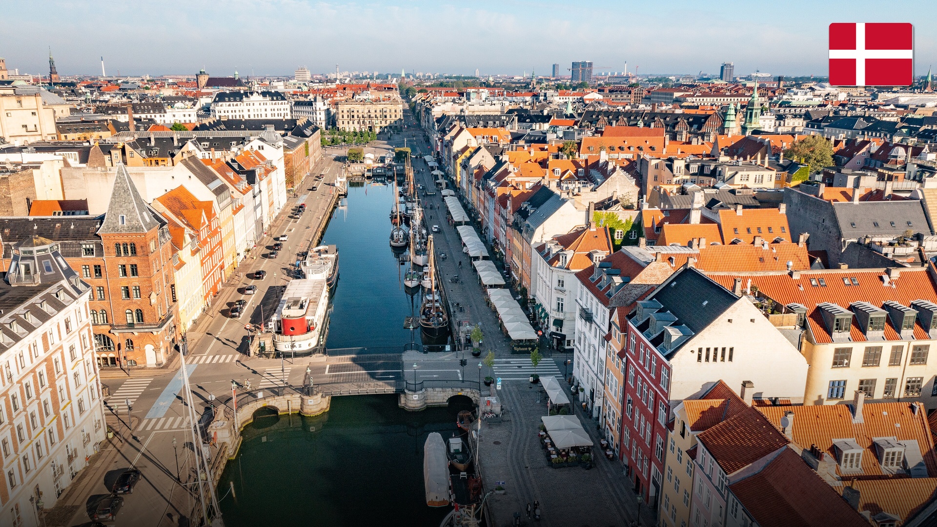 Vibrantly colored 17th-century townhouses and wooden sailing boats in Nyhavn, Copenhagen.