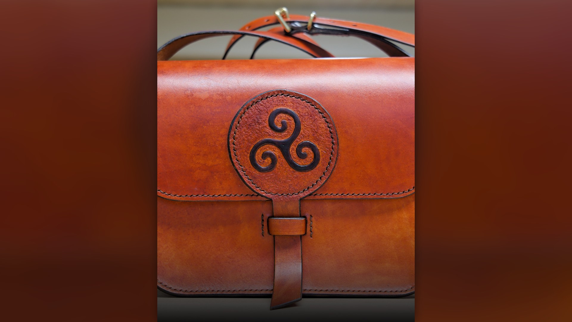 Close-up of a brown leather handbag resting on a wooden surface.