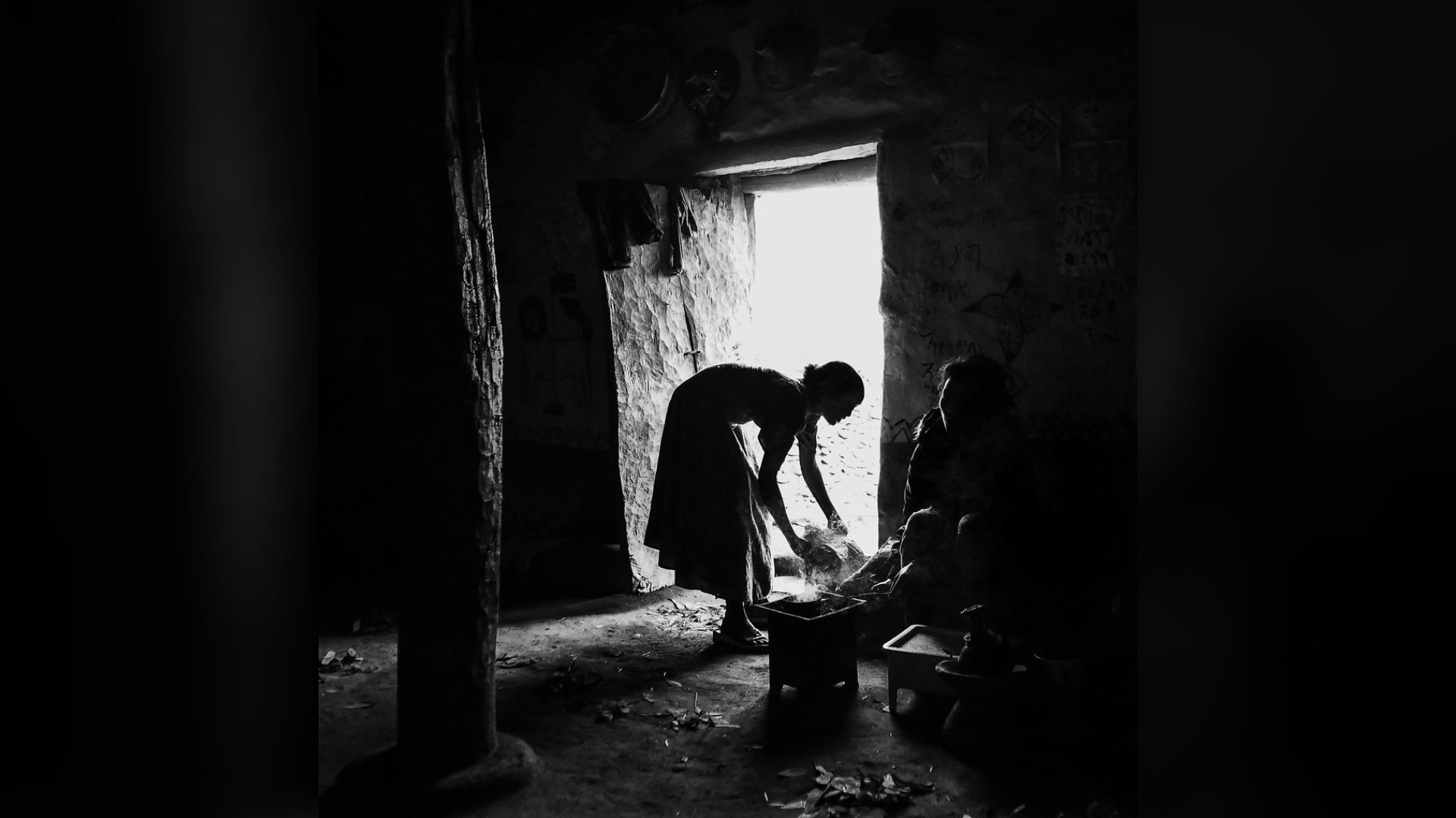 Ethiopian woman preparing traditional Buna coffee ceremony, roasting green coffee beans over open flame